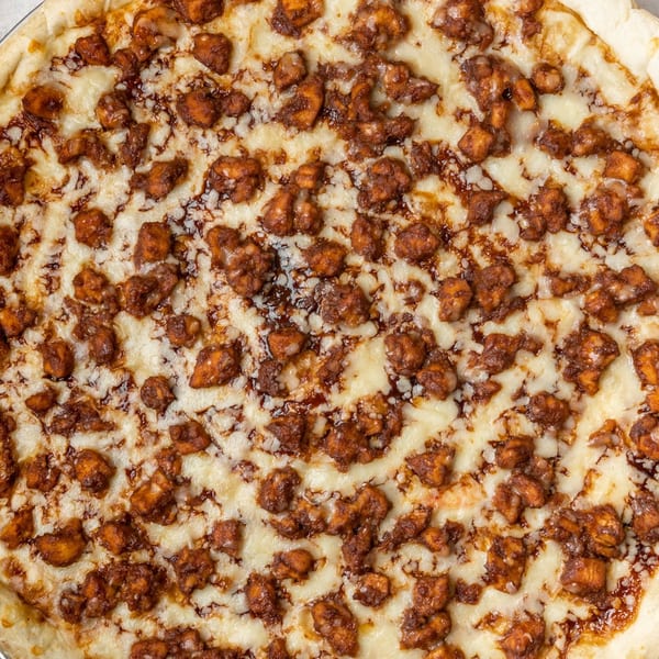 Farmers Pizza's BBQ chicken pizza, topped with melted mozzarella cheese and savory chicken pieces.